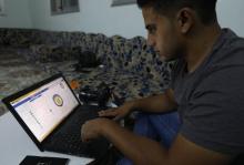 Le militant Khaled al-Idlibi regarde son ordinateur dans la ville d'Idleb, dans le nord-ouest de la Syrie, le 19 août 2018