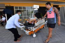 Un touriste étranger blessé est acheminé à l'hôpital Ruslan à Mataram sur l'île indonésienne de Lombok, le 6 août 2018. Environ 1.200 touristes sont en cours d'évacuation lundi des petites îles indoné