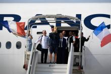 Le capitaine des Bleus Hugo Lloris brandit le trophée de champion du monde aux côtés de Didier Deschamps et Le Graët, le 16 juillet 2018 à l'Aéroport de Roissy