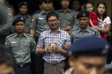 Le journaliste birman Wa Lone escorté de policiers lors de son procès à Rangoun le 20 août 2018
