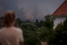 Une femme observe la progression d'un incendie près de la ville touristique de Monchique, dans l'Algarve, le 4 août 2018 au Portugal