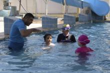 Des filles avec leur entraîneur de natation dans une piscine de Mossoul le 13 août 2018