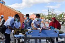 Des équipes médicales prennent en charge des blessés dans un hôpital de fortune, le 6 août 2018 à Mataram, après un séisme meurtrier sur l'île de Lombok, en Indonésie