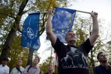 Un homme portant des drapeaux de l'Otan et de l'Union européenne, le 20 août 2018 à Prague