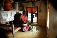 Une Indienne est assise dans sa maison envahie par les flots dans l'Etat du Kerala, le 10 août 2018.
