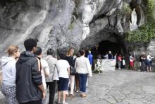 Des pèlerins devant la grotte Massabielle à Lourdes le 15 août 2017