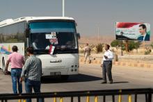 Un bus décoré de portraits du président syrien Bachar al-Assad transporte des réfugiés rentrant en Syrie. Photo prise le 13 août au poste-frontière de Jdeidet Yabous lors d'un tour organisé par l'armé