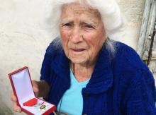 Geneviève Callerot, 102 ans, pose, le 25 août 2018 à Saint-Aulaye (Dordogne), avec sa Légion d'honneur dont elle a été décorée pour avoir fait passer en zone libre réfugiés et juifs durand la 2nde Gue