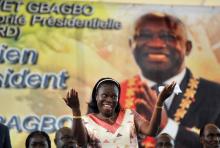 Simone Gbagbo, le 15 janvier 2011, danse devant un portrait de son mari, le président ivoirien Laurent Gbagbo, lors d'un meeting électoral à Abidjan.