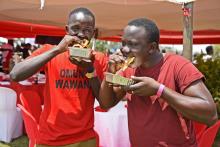 Des hommes mangent un Rolex pendant le Festival annuel Rolex à Kampala le 19 aout 2018