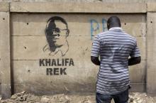 Un artiste observe une effigie du maire de Dakar, Khalifa Sall, sur un mur de la capitale sénégalaise, portant l'inscription "Khalifa Rek" ("Khalifa seulement"), le 28 mars 2018