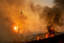 Un hélicoptère lutte contre les flammes de l'incendie du Mendocino Complex, le 5 août 2018 en Californie