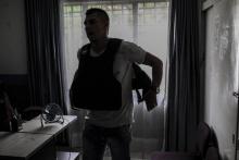 Le militant des droits de l'homme colombien James Zuluaga enfile son gilet pare-balles, dans son bureau de Medellin en Colombie, le 19 juillet 2018