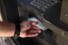 Retrait de Bolivars dans un distributeur automatique de billets à Caracas, le 20 août 2018