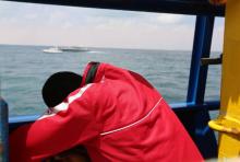 Un migrant à bord du bateau "Sarost 5" au large du port tunisien de Zarzis le 1er août 2018