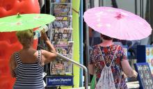 Deux femmes se protègent du soleil avec des ombrelles à Benidorm, le 5 août 2018