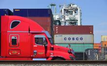Un camion passe devant des conteneurs, dont l'un appartenant au groupe chinois Cosco, le 6 juillet 2018 dans le port de Long Beach, en Californie