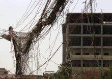 Une photo prise le 26 juillet 2018, montre des entrelas de fils électriques liés à des générateurs installés à Bagdad pour compenser les coupures de courant dans la capitale irakienne