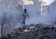Des Syriens utilisent de la poussière pour éteindre un incendie sur le lieu d'une frappe aérienne présumée à Jisr al-Choughour, dans la province d'Idleb, dans le nord-ouest de la Syrie, le 4 septembre