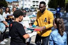 Le rappeur Mac Tyer distribue des fournitures scolaires à des enfants, à la cité des Fusains, le 1er septembre 2018 à Aubervilliers