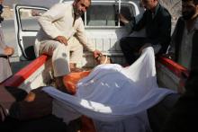 Des hommes transportent un autre homme tué dans un attentat dans l'est de l'Afghanistan, le 11 septembre 2018