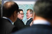 Les visiteurs d'une exposition visant à soutenir le nouveau sommet bilatéral prévu cette semaine en Corée du nord contemplent, lundi 17 septembre 2018 à Séoul, la photo d'une précédente rencontre entr