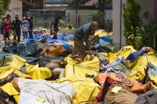 Des indonésiens récupèrent des affaires dans les décombres de leurs maisons après un séisme et un tsunami à Palu, dans l'île des Célèbes, le 29 septembre 2018