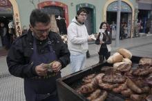 Un touriste déjeune d'une saucisse, lors d'une visite dans le quartier traditionnel de La Boca à Buenos Aires, le 14 septembre 2018