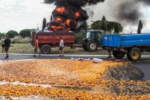 Des agriculteurs ont renversé des remorques de fruits et mis le feu à des pneus, sur le rond point d'accès à la plateforme logistique de Saint-Charles de Perpignan, le 24 septembre 2018