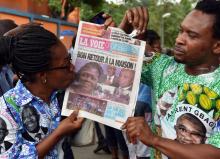 Une partisane de l'ancienne première dame de Côte d'Ivoire, Simone Gbagbo, libérée de prison début août 2018, embrasse un journal ivoirien où se trouve sa photo à la une
