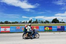 Une moto passe le 30 août 2018 devant des banderoles souhaitant la bienvenue aux délégués des 18 pays et territoires associés qui se réunissent à Nauru à l'occasion du 18e Forum des Îles du Pacifique 