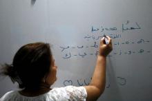 Samira Hanna, une enseigante note sur le tableau des lettres en syriaque dans une école du nord-est de la ville syrienne de Qamichli le 30 août 2018