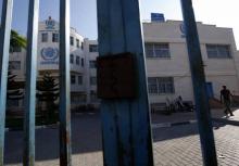 Palestinians are seen behind the closed gate of United Nations Relief and Works Agency (UNRWA) during a strike of all UNRWA institutions in Rafah in the southern Gaza Strip on September 24, 2018.Washi