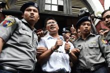 Le journaliste birman Wa Lone (C) escorté par des policiers après sa condamnation à sept ans de prison, à Rangoun le 3 septembre 2018