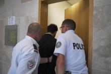 Le chanteur marocain Saad Lamjarred (C) escorté par deux policiers à la cour d'appel d'Aix-en-Provence, le 18 septembre 2018