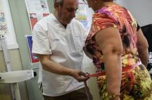Le Dr Carlos Pineiro, médecin à Naron en Espagne, où la population compte perdre 100.000 kilos, mesure la taille d'une candidate au régime, le 13 septembre 2018