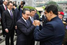 Le ministre des Affaires étrangères chinois Wang Yi serre les mains du président vénézuélien Nicolas Maduro à Pékin, le 14 septembre 2018