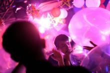 Des jeunes vietnamiens respirent le contenu de "funky balloons" remplis de gaz hillarant, dans une discothèque à Hanoi, le 22 septembre 2018