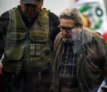 L'ancien dirigeant de la guérilla péruvienne du Sentier lumineux Abimael Guzman est amené par un policier à son procès à Callao près de Lima, le 11 septembre 2018.