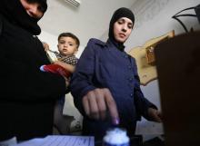 Une électrice trempe son doigt dans l'encre après avoir voté le 16 septembre à Damas.