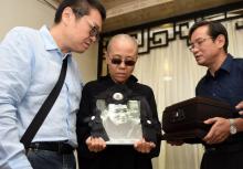 Liu Xia (c), la veuve du prix Nobel de la Paix chinois Liu Xiaobo, tient un portrait du dissident et