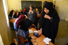 Une employée électorale enregistre l'empreinte biométique d'une votante lors des législatives, le 20 octobre 2018 à Hérat, en Afghanistan