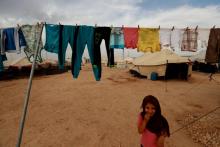 Une fillette originaire de la province de Deir Ezzor, dans l'est de la Syrie, se tient debout dans un camp de déplacés dans la province voisine de Hassaké le 8 octobre 2018