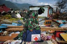 Un soldat indonésien marche dans les décombres dans le quartier de Perumnas Balaroa à Palu, après un séisme suivi d'un tremblement de terre, dans l'île des Célèbes en Indonésie le 6 octobre 2018