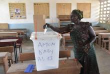 Une femme met son bulletin dans l'urne, dans un bureau de vote du Plateau, à Abidjan, pour les municipales et régionales du 13 octobre 2018