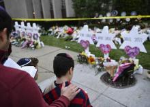Des gens se recueillent devant la synagogue de Pittsburgh, où un mémorial pour les 11 victimes tuées par un tireur samedi a été installé, le 29 octobre 2018.
