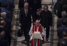 Les parents de Matthew Shepard, Judy et Dennis, marchent derrière l'évêque Gene Robinson qui porte les cendres de leur fils le 26 octobre 2018 à la Washington National Cathedral