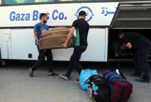 Des Palestiniens mettent des valises dans un bus qui doit traverser la frontière entre la bande de Gaza et l'Egypte, au point de passage de Rafah, le 26 septembre 2018