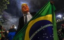 Un partisan du futur président du Brésil Jair Bolsonaro porte un masque à l'éffigie du président américain Donald Trump, le 28 octobre 2018 à Sao Paulo.