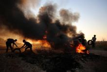 Des Palestiniens brûlent des pneus près de la barrière séparant Gaza et Israël, le 12 octobre 2018.